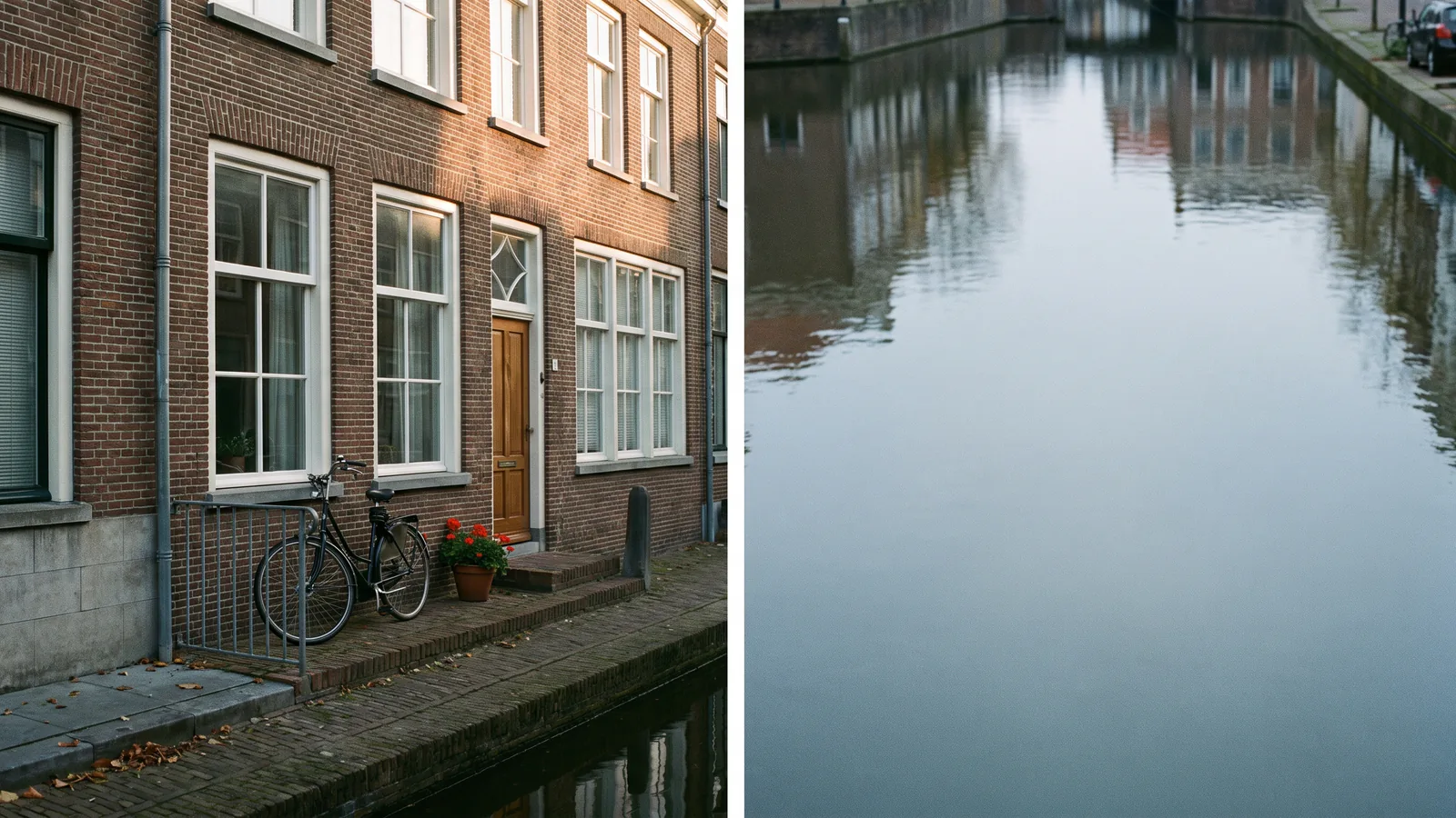 Una casa adosada holandesa junto a un canal, con fachada de ladrillo y ventanas altas, fotografiada desde la otra orilla en una tarde nublada de otoño, con una bicicleta apoyada en la barandilla y geranios en el escalón.